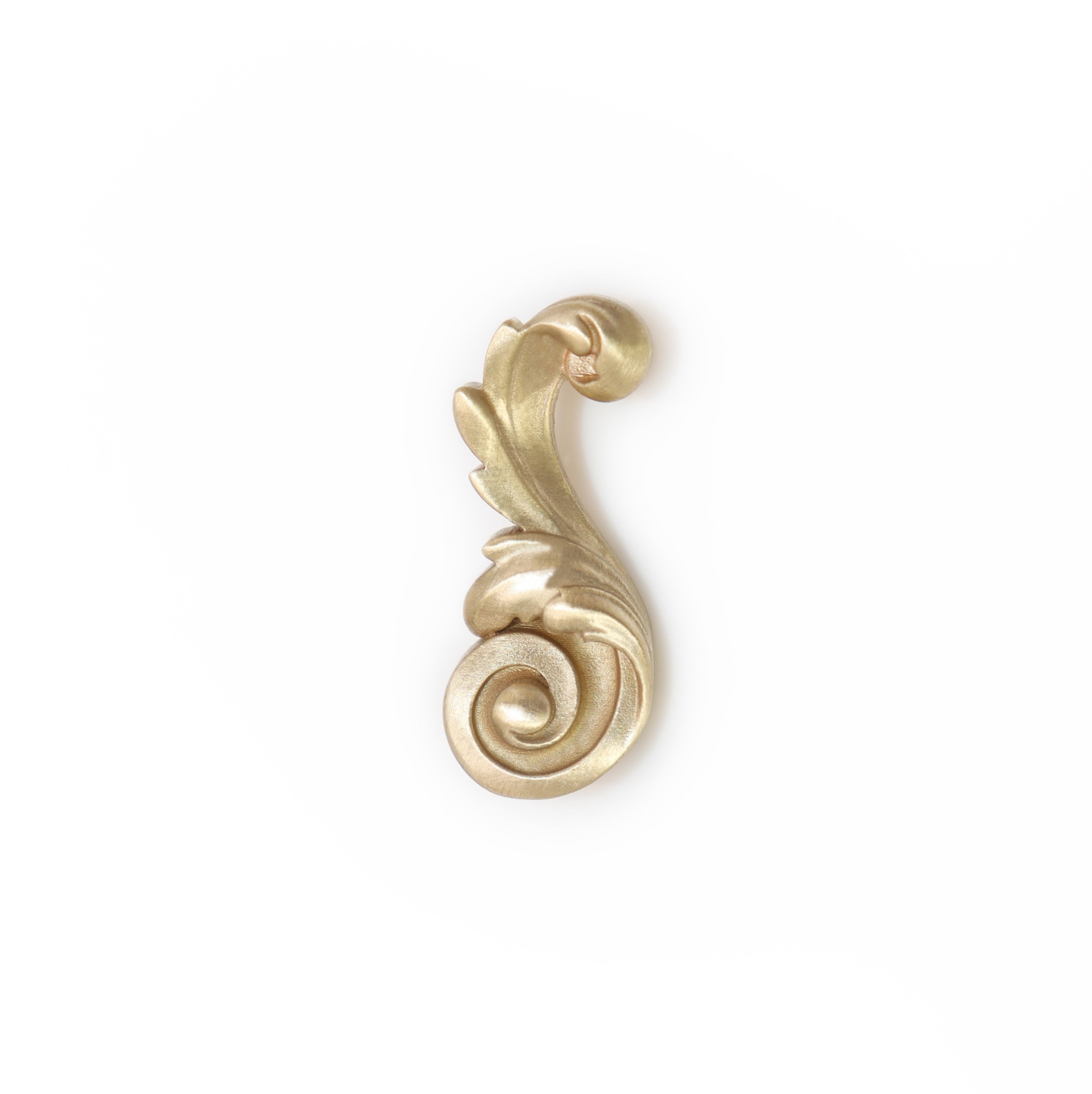 Decorative gold Acanthus leaf brooch design on a white background