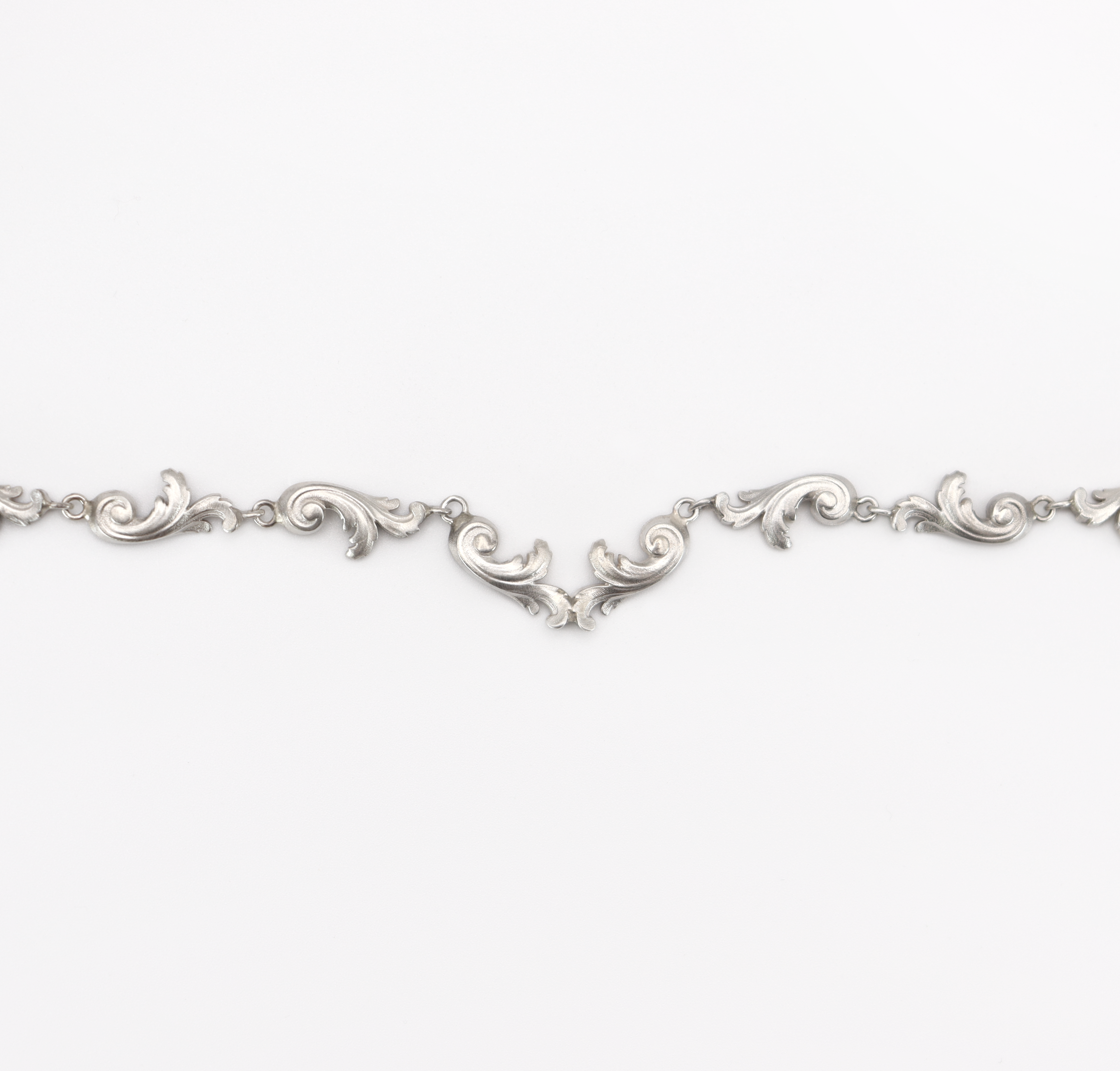 Silver bracelet with intricate designs on a white background