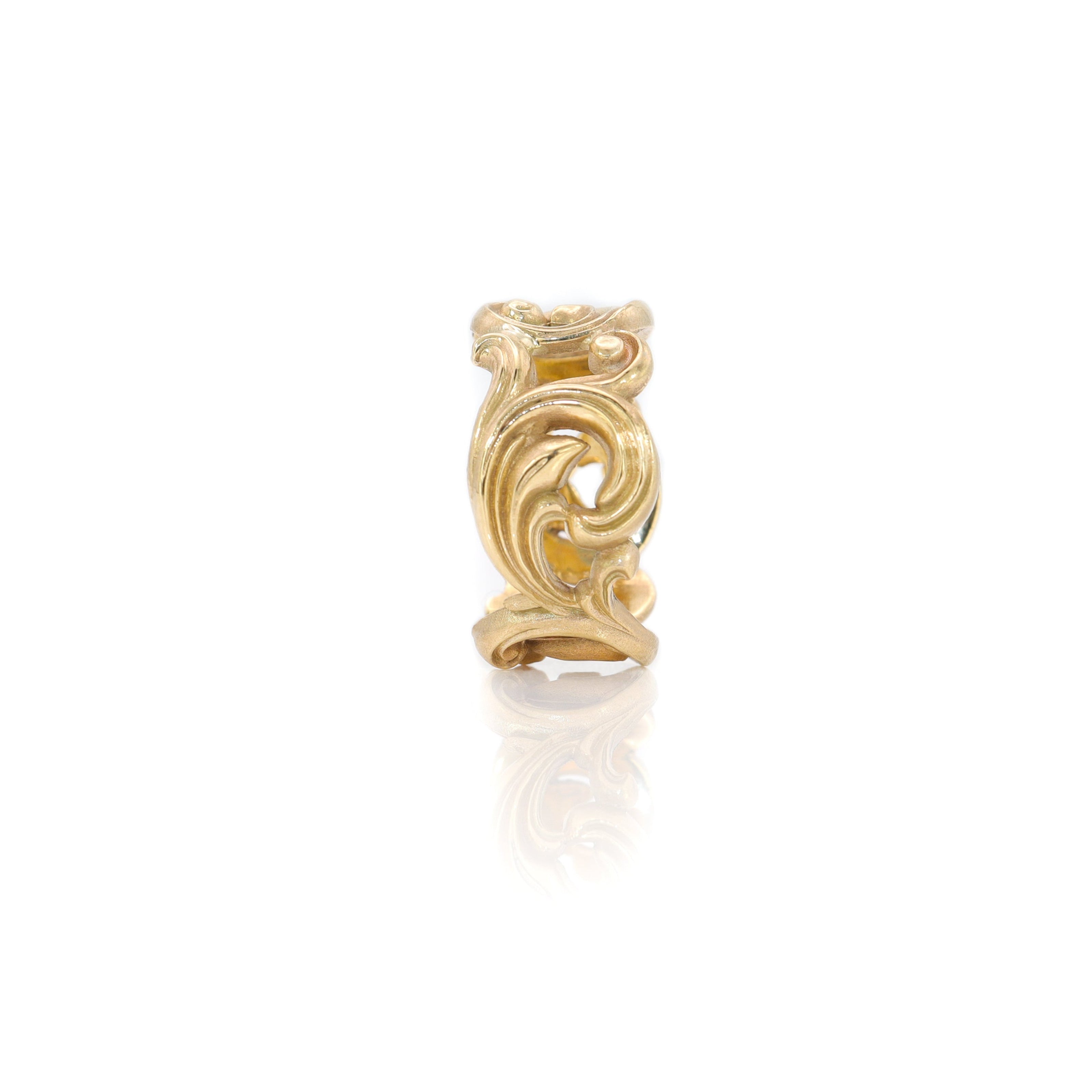 Gold scroll ring on a white background