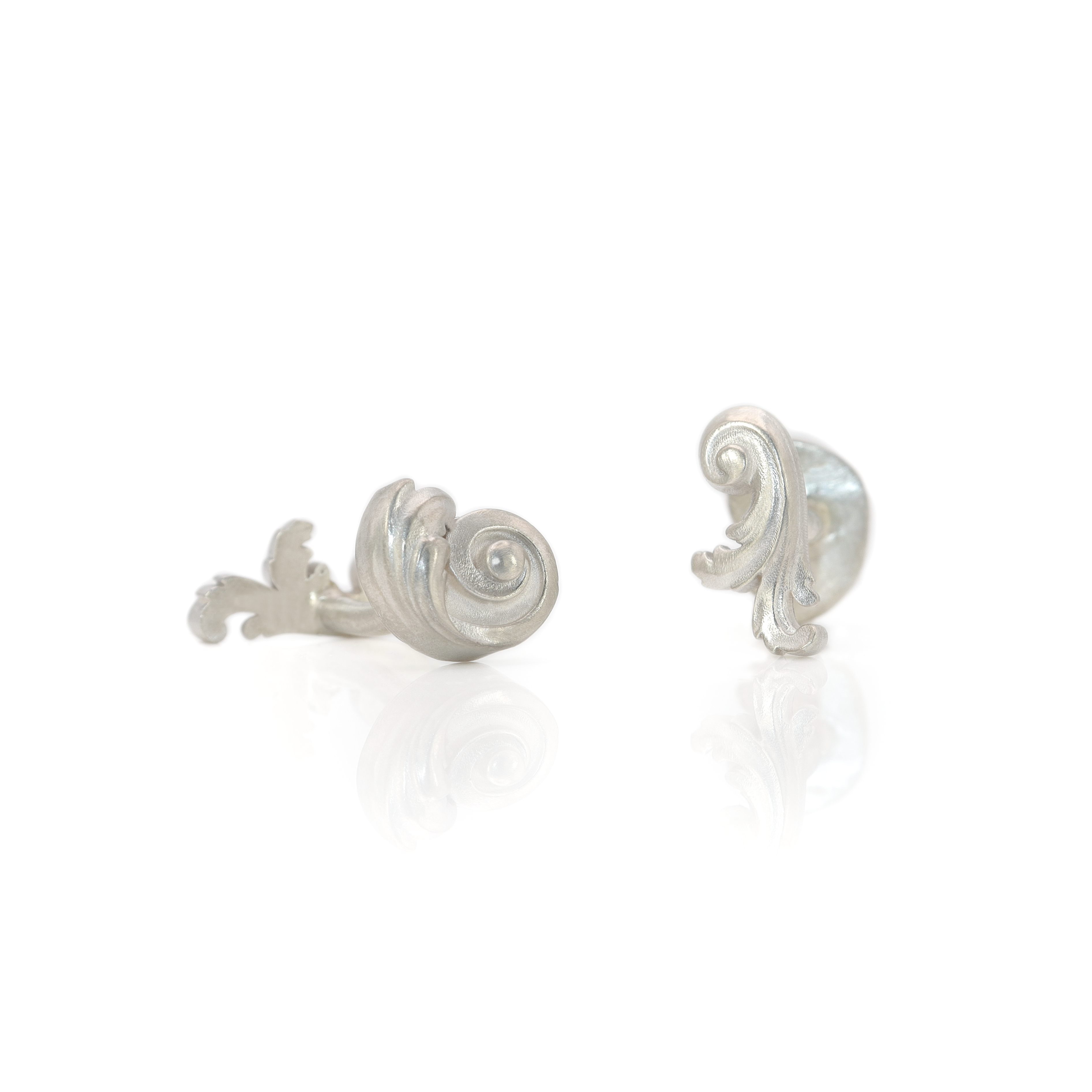 Pair of silver acanthus leaf earrings on a white background